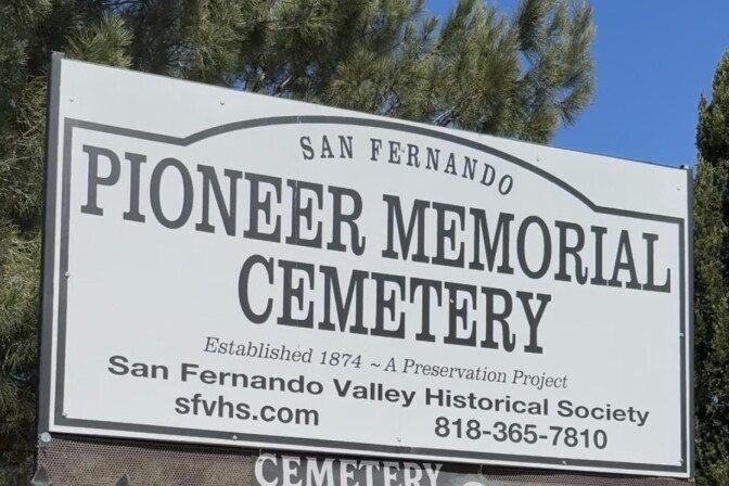 A sign that says "Pioneer Memorial Cemetery" in front of a cemetery