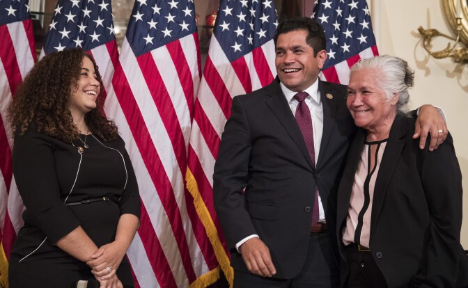 Representative-elect Jimmy Gomez, D-Calif., center, puts his arm around his mother Socorro Gomez, right, as he wife Mary Hodge look on at left, before participating in a ceremonial swearing-in on Capitol Hill in Washington, Tuesday, July 11, 2017.