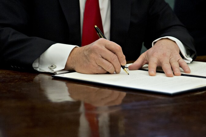 WASHINGTON, DC - JANUARY 30:  (AFP OUT) U.S. President Donald Trump signs an executive order in the Oval Office of the White House January 30, 2017 in Washington, DC. Trump said he will "dramatically" reduce small business regulations overall with this executive action. (Photo by Andrew Harrer - Pool/Getty Images)