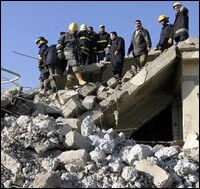 Iraqi firefighters search for wounded people amid rubble at the site of a deadly explosion in Mosul, Jan. 24, 2008.