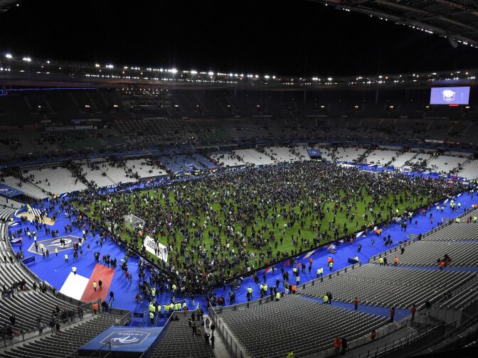 Spectators gather on the pitch of the Stade de France stadium following the friendly football match between France and Germany in Saint-Denis, north of Paris, on November 13, 2015, after a series of gun attacks occurred across Paris as well as explosions outside the national stadium where France was hosting Germany. At least 18 people were killed, with at least 15 people killed at the Bataclan concert hall in central Paris, only around 200 metres from the former offices of Charlie Hebdo which were attacked by jihadists in January.  AFP PHOTO / FRANCK FIFE        (Photo credit should read FRANCK FIFE/AFP/Getty Images)