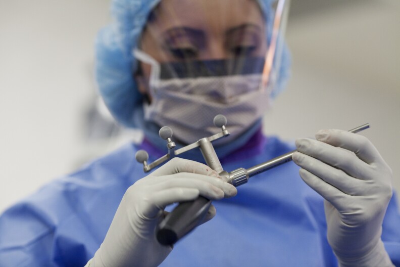 Surgical Technician Daniela Barrio prepares equipment before a spinal surgery at Foothills Presbyterian Hospital in Glendora. The surgeon Barrio was working with is not part of a physician-owned distributorship,  but the practice of surgeons using implants that they have a financial interest in under scrutiny from the Department of Health and Human Services.