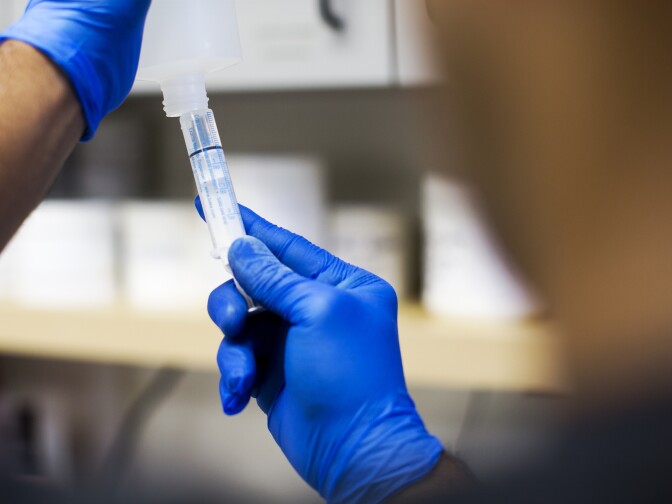 A pharmacist then adds a solvent to the powdered drug, which solvent helps dissolve it.