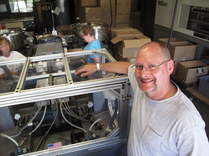 Stephen Mullany, who runs The Wiffle Ball Inc. with his brother David, poses in front of the machine that presses the two plastic ball halves together at a factory in Shelton, Conn. Mullany's grandfather invented the Wiffle Ball in the 1950s.
