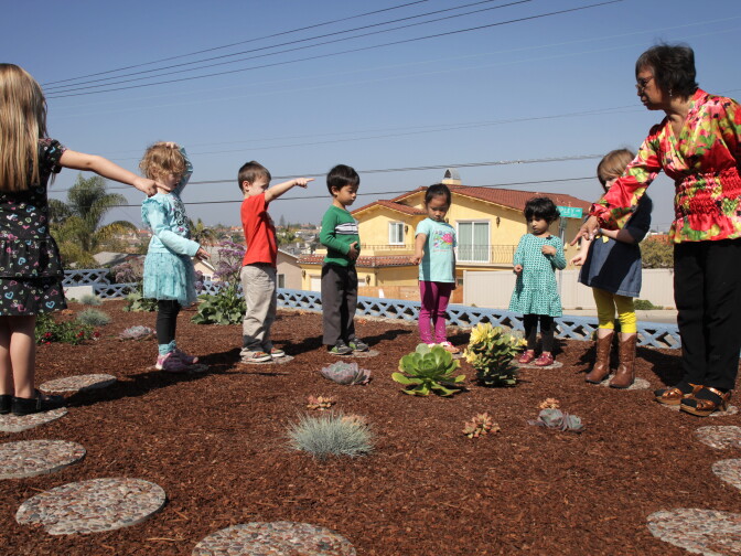 Teacher Ginny Zywot shows her Smart Start Preschool students around their drought-resistant garden that they built to conserve water and promote native plant growth in Redondo Beach, Calif.