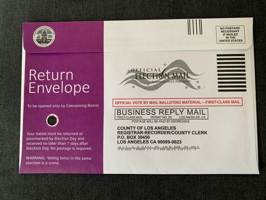 A close-up image of a return envelope for a mail-in ballot. The left side is purple and reads "Return Envelope" in large text. There is a small hole underneath that text.