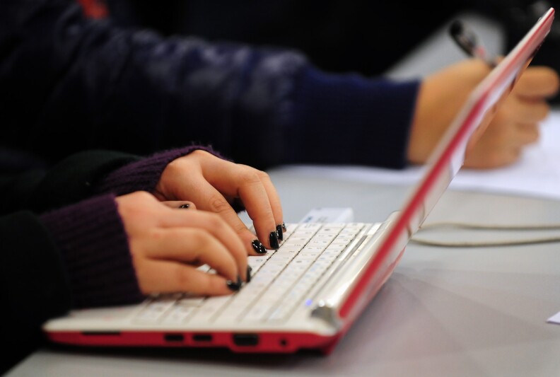 This photo shows a woman typing on the keyboard of her laptop computer in Beijing.