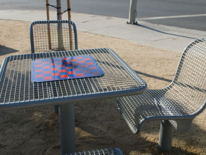 The game table in the park provides a place for the elderly community to both play and rest.