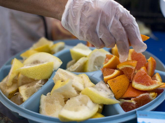 Rosario Mireles, an operations associate for Village Market Place, puts out free samples of yellow grapefruit and orange. The free samples help attract new customers, Mirales said.