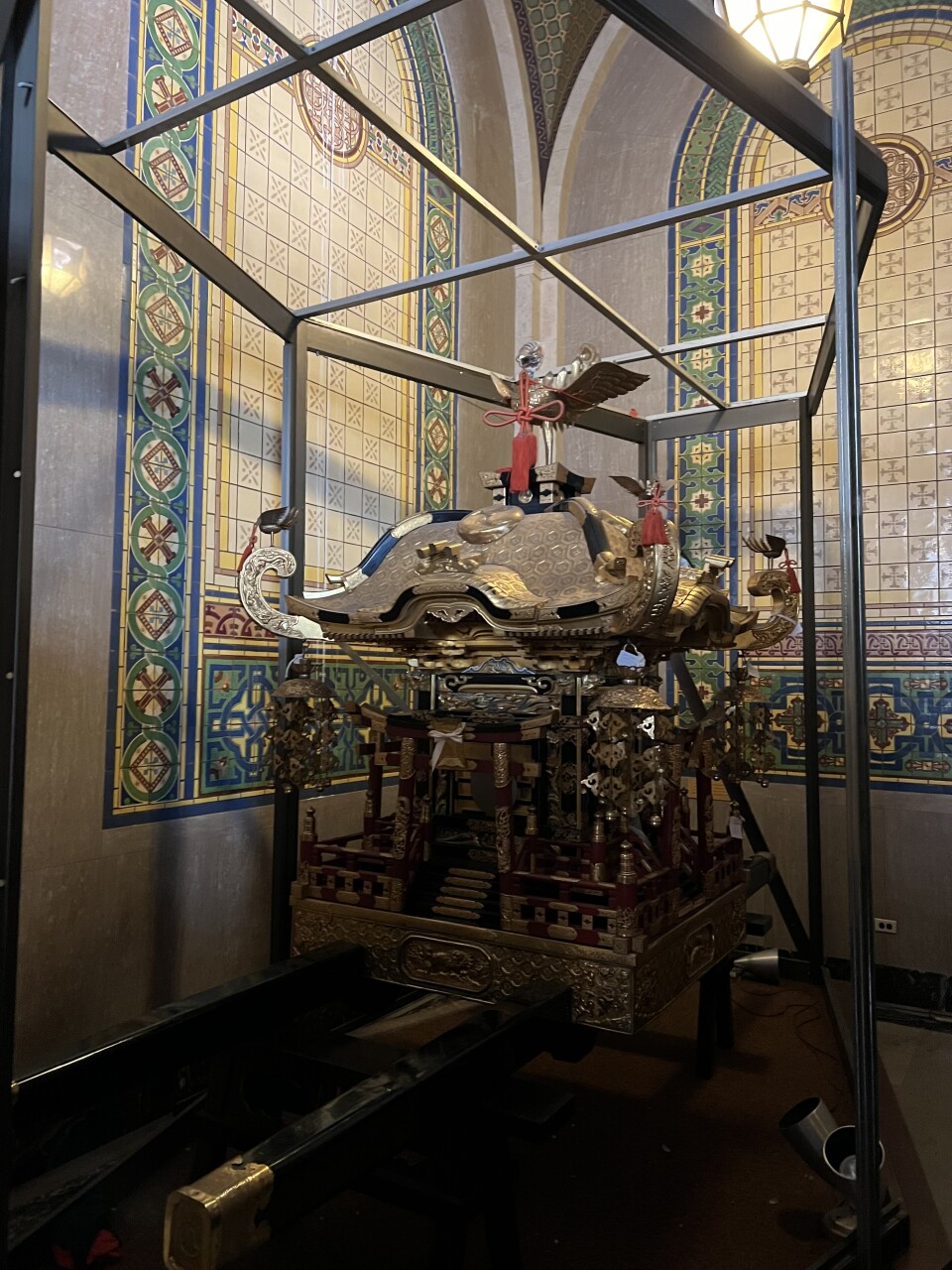 An ornate Japanese wooden shrine is displayed in the corner of the room. 