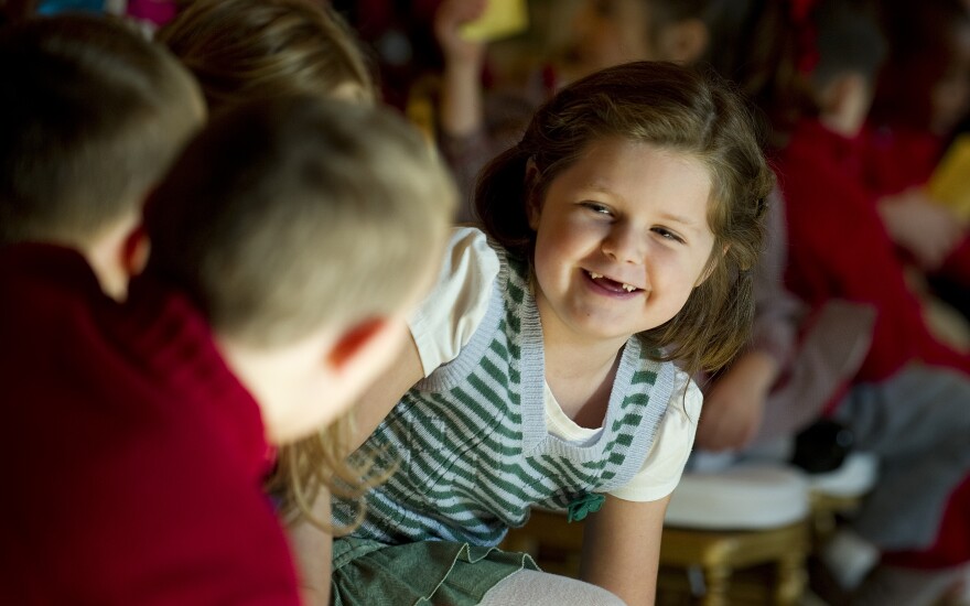 Six-year-old Carolyn Hoagland (C)  laughs with other children of active duty military personnel while awaiting the arrival of First Lady Michell Obama during the press preview of the White House Christmas decorations in Washington, DC, November 30, 2011. The White House chose a theme of "Shine, Give, Share" celebrating the countless ways we can lift up those around us.      AFP PHOTO/Jim WATSON (Photo credit should read JIM WATSON/AFP/Getty Images)