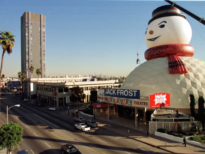 Finishing touches are put on a giant snowman's head sitting atop the dome of the Pacific Cinerama Theatre on Sunset Boulevard in Hollywood, CA 07 December. The snowman is part of the advertising for the movie 'Jack Frost' starring Michael Keaton.  