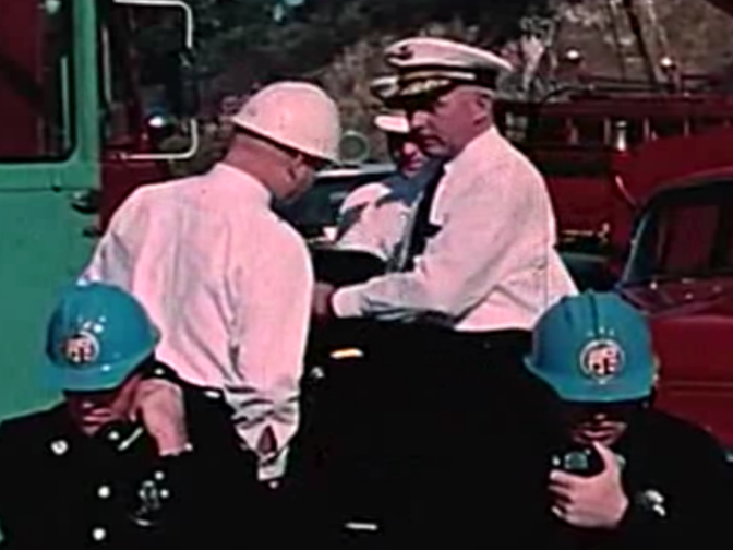 Officials gather to discuss the fire in this scene from 'Design for Disaster.'