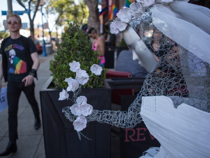 A bride statue holds flowers outside of Revolver, a bar on Santa Monica Boulevard in West Hollywood.