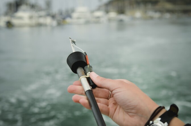 A research assistant working for Dr. Chris Lowe of California State University, Long Beach, attaches a device to a pole used to tag sharks for a research project near San Clemente, Tuesday June 28, 2017.
