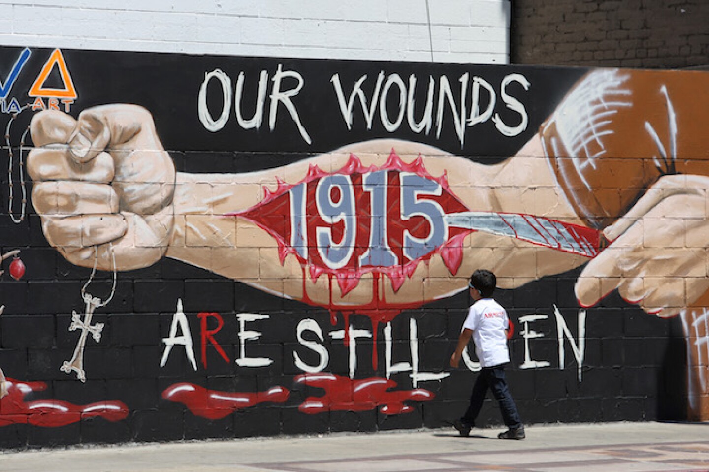A boy looks at a mural commemorating the 1915 Armenian Genocide on Hollywood Boulevard near a rally on the 99th anniversary of the event.