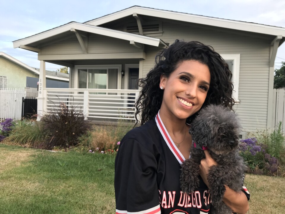 Jackie Dillon stands in front of the South Los Angeles home she purchased earlier this year, July 18, 2018. (David Wagner/KPCC)