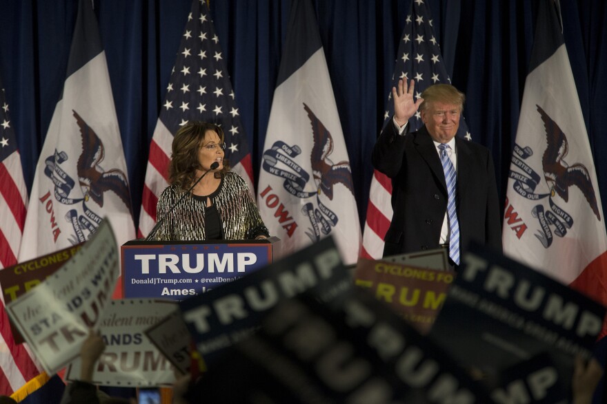 Republican presidential candidate Donald Trump acknowledges the crowd as former Alaska Gov. Sarah Palin speaks at Hansen Agriculture Student Learning Center at Iowa State University on January 19, 2016.