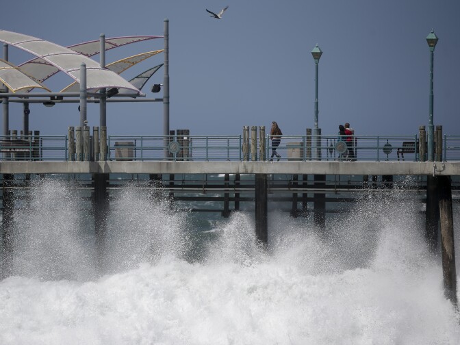 Waves hit the Redondo Beach Pier in Redondo Beach, Calif., Monday, April 8, 2013. Strong winds have begun raking parts of Southern California. The National Weather Service says the gusty northwest-to-north winds will become widespread across the region Monday and continue into the night.