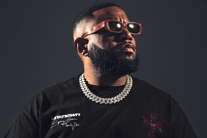 Gordo in profile with sunglasses, black t-shirt and silver chain