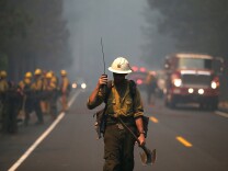 GROVELAND, CA - AUGUST 22:  A U.S. Forest Service firefighter monitors a radio while battling the Rim Fire on August 22, 2013 in Groveland, California. The Rim Fire continues to burn out of control and threatens 2,500 homes outside of Yosemite National Park. Over 1,000 firefighters are battling the blaze that was reduced to only 2 percent containment after it nearly tripled in size overnight.  (Photo by Justin Sullivan/Getty Images)