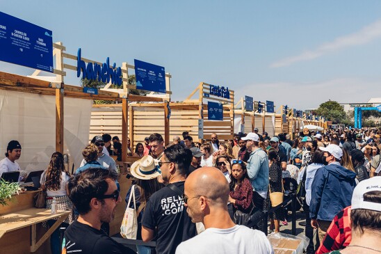 Groups of people stand in front of food stands.