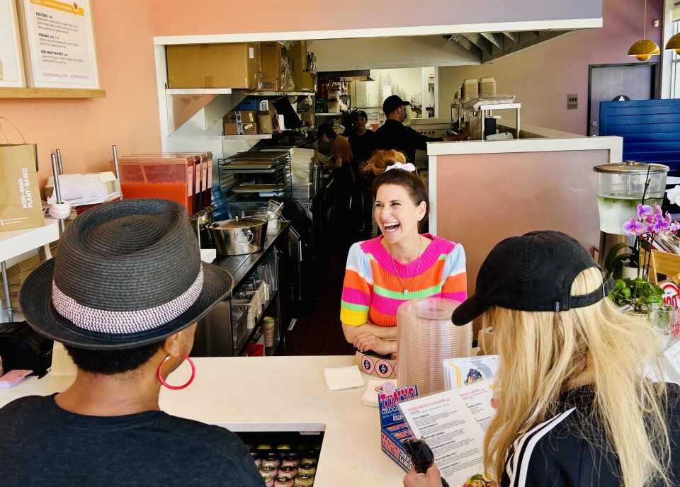 Three people at a restaurant counter.