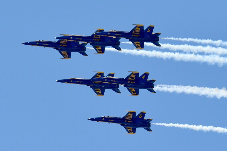 The US Navy's Blue Angels flying in formation against a clear blue sky.