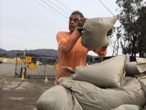 George Rodriguez, 69, a volunteer, loads sandbags at the Glendora City Yard. 