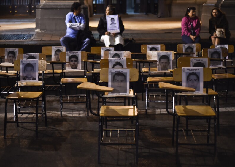 Chairs with portraits of missing students are seen during a march demanding justice for the 43 missing students along a street in Mexico City on October 22, 2014. Mexican authorities ordered the arrest of the mayor of the city of Iguala, Jose Luis Abarca, his wife and an aide, charging them with masterminding last month's attack that left six students dead and 43 missing. 