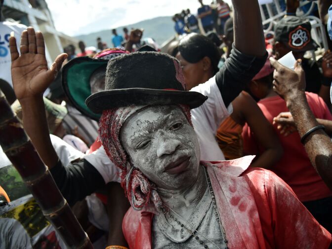 A devotee pretending to be the spirit known as a Gede smiles during a ceremony honoring the Haitian voodoo spirits of Baron Samdi and Gede on the Day of the Dead in the National Cemetery in Port-au-Prince, Haiti on November 1, 2016.