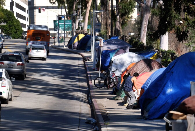 FILE - This Tuesday, Jan. 26, 2016 file photo shows tents from a homeless encampment line a street in downtown Los Angeles. Los Angeles city and county officials have approved sweeping plans to deal with homelessness at a cost of billions over a decade. The City Council's strategic plan calls for providing more housing and funding programs designed to keep people off the streets in the first place. The city has around 25,000 homeless, more than half the total in LA County. (AP Photo/Richard Vogel,File)