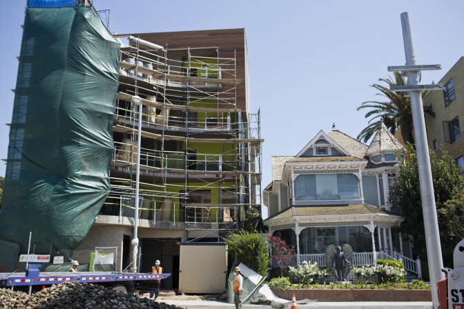 An under-construction five-story building, left, sits adjacent to a two-story Victorian house, Angel's Attic Museum, on Colorado Boulevard between Fifth and Sixth Streets in Santa Monica.