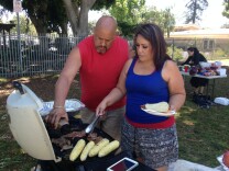 Javier Velasquez and his wife add spices to the carne asada on the grill. The family has been celebrating July 4 at South Gate Park for 13 years.