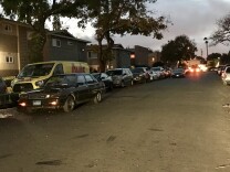 Cars double parked along an Anaheim street at dusk. 