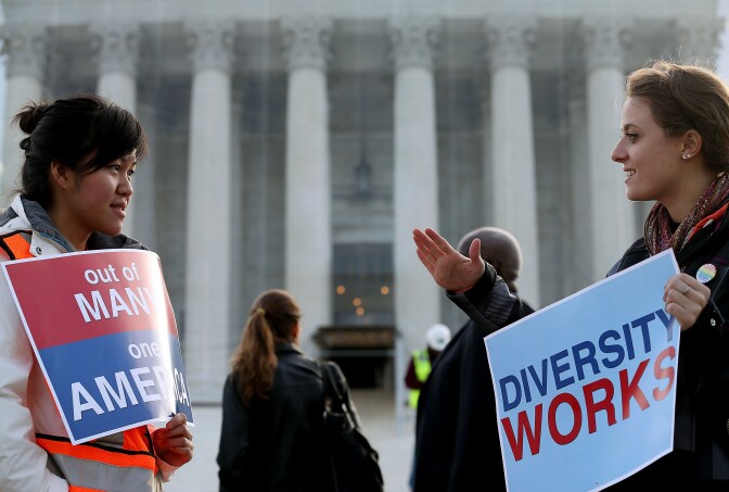 WASHINGTON, DC - OCTOBER 10: Helen Tran (L) and Jennifer Hicks protest in front of the U.S. Supreme Court on October 10, 2012 in Washington, DC. Today the high court is scheduled to hear arguments on Fisher V. University of Texas at Austin, and are tasked with ruling on whether the university's consideration of race in admissions is constitutional.  (Photo by Mark Wilson/Getty Images)