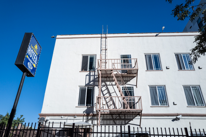 A fire escape sits on the side of a white building.