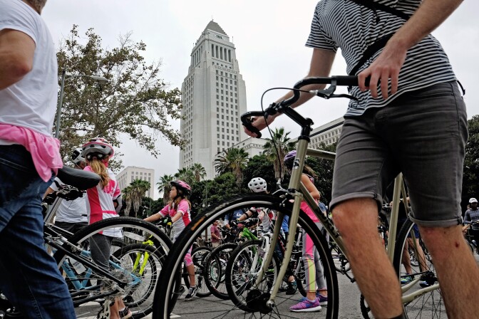 Cyclists make their way through an intersection past City Hall in downtown Los Angeles on Sunday, Oct. 18, 2015. Six miles of streets in and around downtown Los Angeles were closed to motor vehicles as the city's fifth anniversary celebration of the CicLAvia festival opened the lanes to cyclists, skaters and pedestrians.