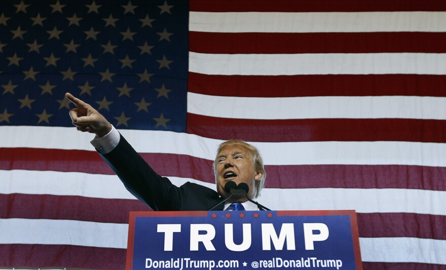 Republican presidential candidate Donald Trump speaks to guest gathered during a campaign event at the International Air Response facility on December 16, 2015 in Mesa, Arizona.