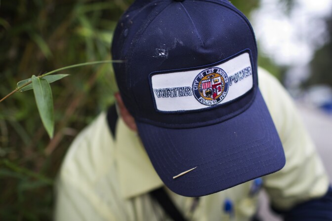 John Cruz, a meter reader for the Los Angeles Department of Water and Power opens a water meter in the Hollywood Hills on Friday morning, Aug. 7, 2015.