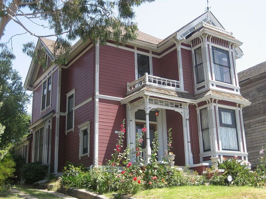 A home, with a white and brown exterior, with unique architecture.