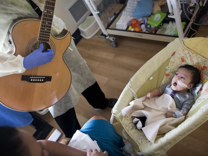 Araceli Viveros' 3-month-old son listens as music therapist Tacy Pillow plays a lullaby on Friday, Feb. 20, 2015 in the Newborn and Infant Critical Care Unit at Children's Hospital Los Angeles. The hospital uses music to help calm babies in the unit.