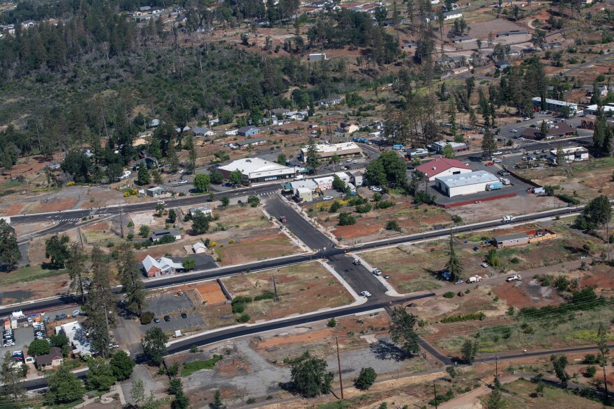 An aerial view of a town with many empty lots and a few structures dotting the otherwise barren landscape