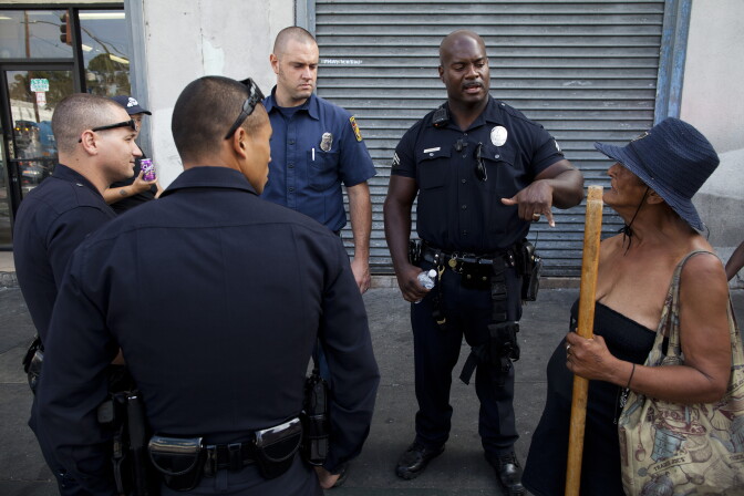 LAPD Officer Deon Joseph and other LAPD officers engage a woman who said she was robbed early in the day on Skid Row.