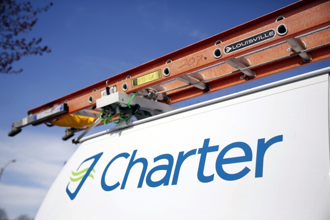 This April 1, 2015 photo shows a Charter Communications van in St. Louis. Charter Communications is close to buying Time Warner Cable for about $55 billion, two people familiar with the negotiations said Monday, May 25, 2015. (AP Photo/Jeff Roberson)