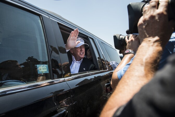 LAREDO, TEXAS - JULY 23: Republican Presidential candidate and business mogul Donald Trump talks to media from his car wearing a, "Make America Great Again," hat during his trip to the border on July 23, 2015 in Laredo, Texas. Trump's recent comments, calling some immigrants from Mexico as drug traffickers and rapists, have stirred up reactions on both sides of the aisle. Although fellow Republican presidential candidate Rick Perry has denounced Trump's comments and his campaign in general, U.S. Senator from Texas Ted-Cruz has so far refused to bash his fellow Republican nominee. (Photo by Matthew Busch/Getty Images)