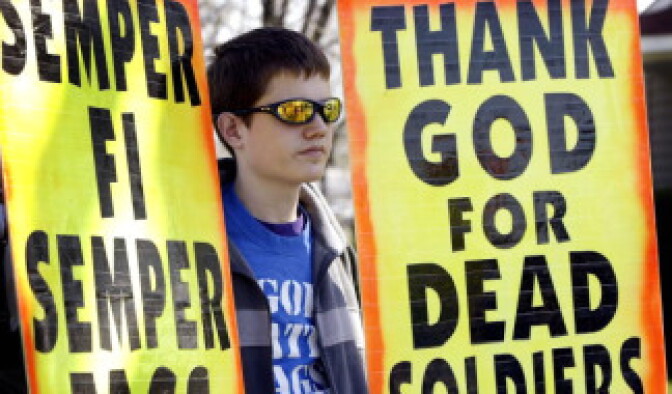 A member of Westboro Baptist Church of Topeka, Kansas, protests outside Holy Ghost Church during the funeral service for Marine Lance Cpl. Philip Martini April 19, 2006 in South Holland, Illinois.