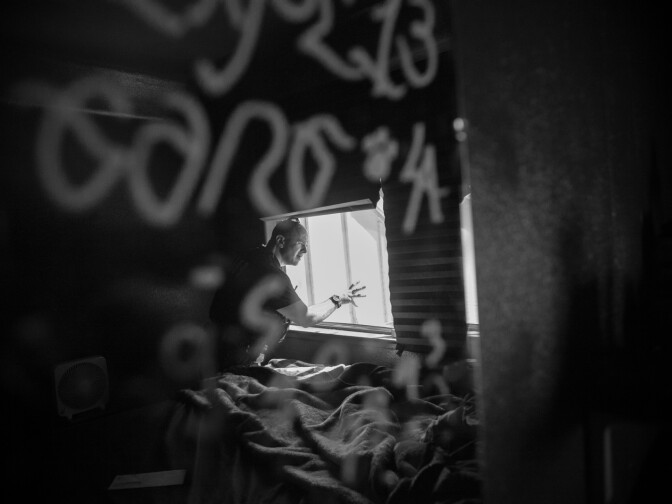 Detective Jones looks for clues in the bedroom of a home in Corona, Calif. The mirror in the bedroom has Los Angeles gang tags.