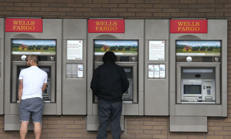 Customers use ATMs at a Wells Fargo Bank branch office on July 12, 2012 in Daly City, California. The Justice Department announced Thursday that Wells Fargo Bank, the largest residential home mortgage originator in the United States, will pay nearly $175 million to settle accusations of discrimination against qualified African-American and Hispanic borrowers between 2004 and 2009. The alleged discrimination is in violation of fair-lending laws. 