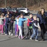 In this photo provided by the Newtown Bee, Connecticut State Police lead children from the Sandy Hook Elementary School in Newtown, Conn., following a reported shooting there Friday, Dec. 14, 2012.